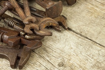Dirty set of hand tools on a wooden background. Old rusty tools. Equipment for locksmith and metalworking shop. Sales tools for assembly workers. Old shop.
