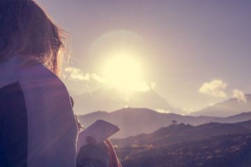 Female traveler writing her thoughts at sunset.