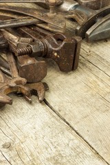 Dirty set of hand tools on a wooden background. Old rusty tools. Equipment for locksmith and metalworking shop. Sales tools for assembly workers. Old shop.
