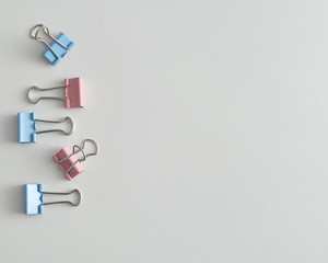 A row of pink and blue binder clips