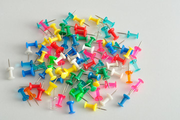 Fototapeta na wymiar Colorful push pins displayed on a white background