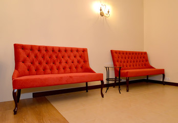 Two red sofas stand at a wall. Drawing room interior