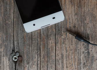 Klinkenstecker / Audiostecker, Smartphone weiß auf Holzuntergrund