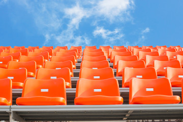 Orange empty stadium seats in arena