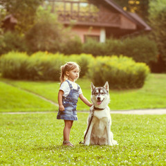 little girl in the park their home with a dog Husky