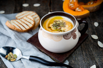 Creamy pumpkin cream soup with pumpkin sunflower seeds and olive oil
