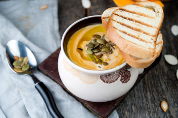 Creamy pumpkin cream soup with pumpkin sunflower seeds and olive oil
