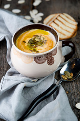 Creamy pumpkin cream soup with pumpkin sunflower seeds and olive oil
