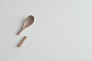 A broken beige glass teaspoon