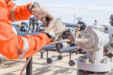 Close-up image of human hand fixing and stop leak stainless tube by wrench in oil and gas process
