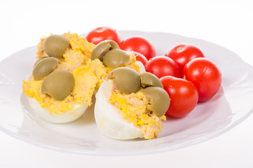 stuffed eggs and red little tomatoes on a pot