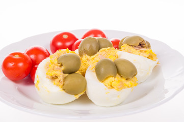 stuffed eggs and red little tomatoes on a pot