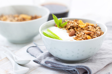 Granola with yogurt and apples in a bowl for breakfast, closeup, horizontal