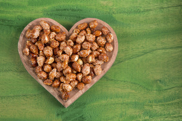 Sugared peanuts on the wooden background