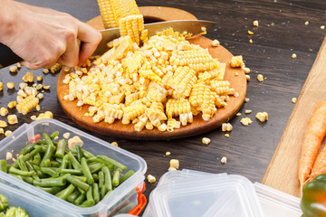 Chef cutting corn for cooking. Stock up on winter food.