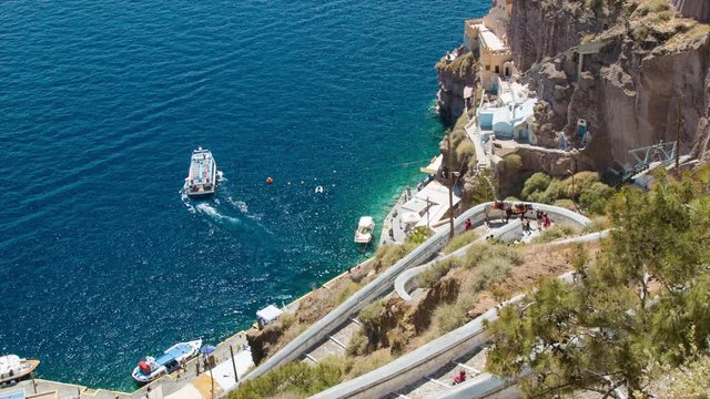 Santorini Greece Cliffside with Donkey Path Meeting the Blue Mediterranean Sea Water with Tender Boats Transporting Passengers Back to the Cruise Ships