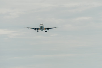 Fototapeta na wymiar Aircraft landing in cloudy day