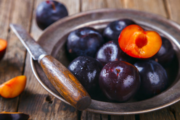 Plum metal plate on wooden vintage background. selective focus.