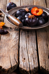Plum metal plate on wooden vintage background. Copy space. selective focus.