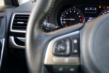Controls on steering wheel and illuminated dashboard inside the vehicle 