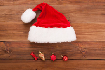 Obraz na płótnie Canvas Santa hat with toys on wooden background.