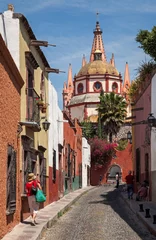 Zelfklevend Fotobehang Beautiful Alley with Colorful Buildings Leading To Parroquia de San Miguel Arcangel church in Mexico © Borna_Mir