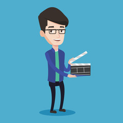 Smiling man holding an open clapperboard.