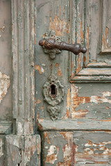 close-up part of the old dilapidated wooden door with handle and keyhole
