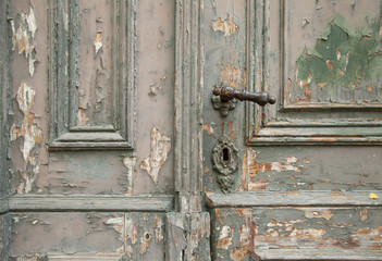 part of the old weathered wooden door with handle and keyhole