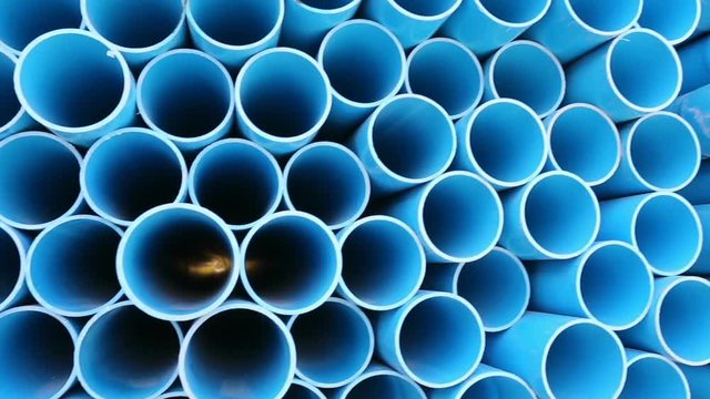 PVC pipes stacked in warehouse.