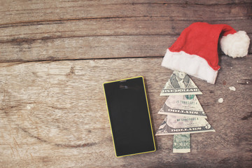 Obraz na płótnie Canvas Smart phone with christmas hat and dollar tree