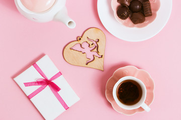 Gift to Valentine's Day, with tea and cupids on a pink background. Top view, film effect