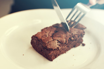 Chocolate brownie, cake on a white plate Vintage color tone.