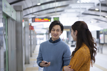 Couple is waiting for a train at the station platform
