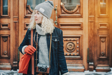 Obraz premium Young blond curly girl with retro film camera, winter