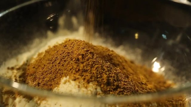 Mixing Spices With White Flour in a Glass Bowl