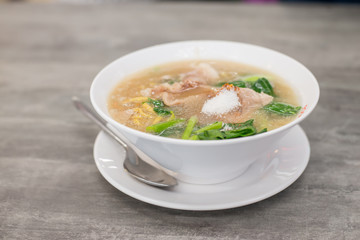 Stir-fried noodles with savory sauce in bowl on wooden table.