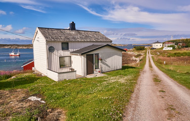 Fototapeta na wymiar White fishermen houses on the banks of the fjord