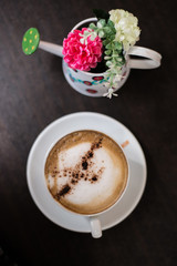 Top view cup of cappuccino on wooden table background.