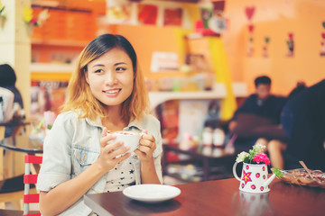 Close-up of woman text messaging with her mobile at coffee shop.