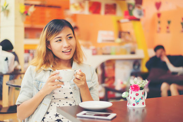 Close-up of woman text messaging with her mobile at coffee shop.