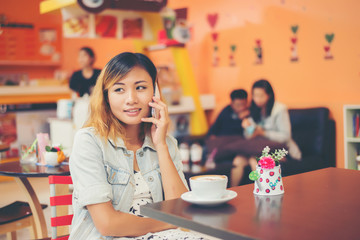 Close-up of woman text messaging with her mobile at coffee shop.