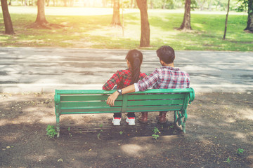 Young teenagers couple in love sitting together on the bench in