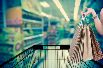 Holding shoping bags by hand on Supermarket with Abstract blurre