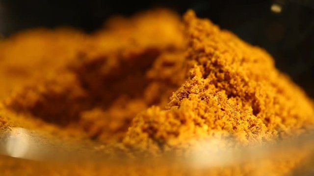 Picking Up A handful of Turmeric Close Up
