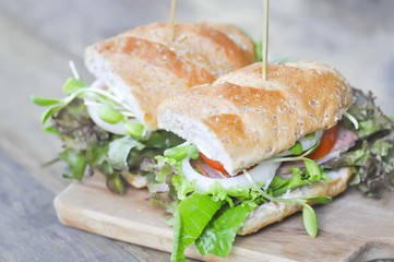 baguette sandwich with ham, tomato,  and lettuce