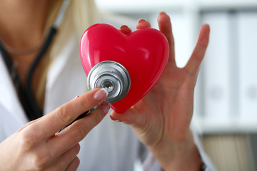 Female medicine doctor hold in hands red toy heart