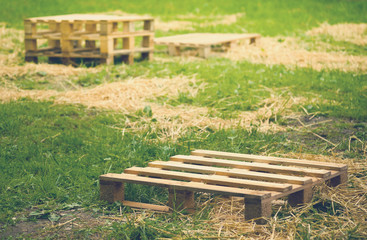 Empty wooden pallets on green grass