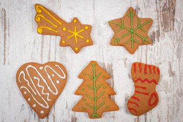 Fresh baked decorated gingerbread on old wooden background, christmas time