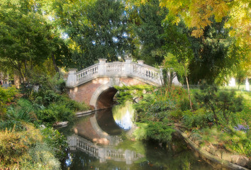 Stone arch bridge over a pond in Parc Monceau in Paris, France